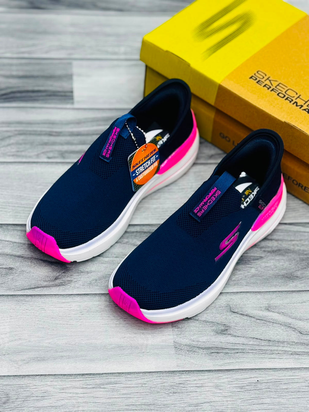 Navy blue and hot pink Skechers Hyper Burst women's slip-on sneakers with Stretch Fit tag