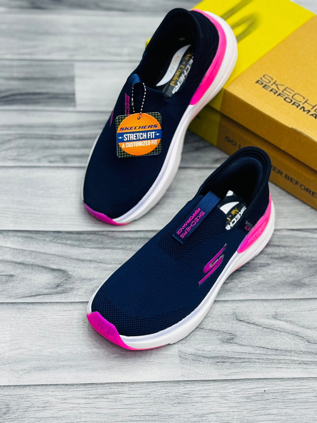 Navy blue and hot pink Skechers Hyper Burst women's slip-on sneakers with Stretch Fit tag