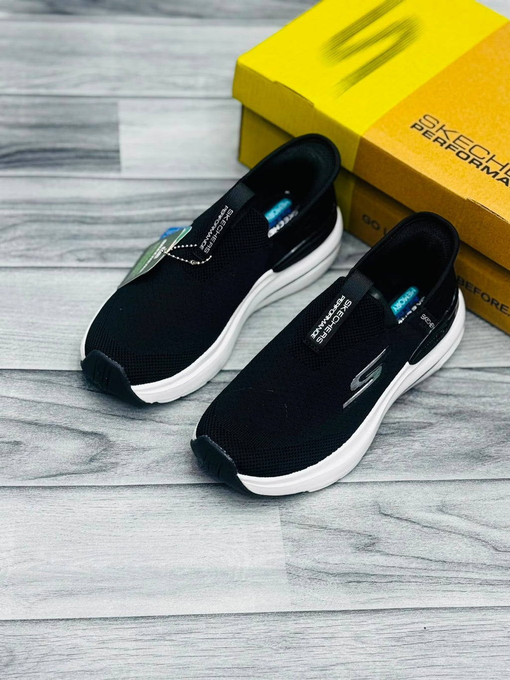 Black and white Skechers Hyper Burst women's slip-on sneakers with Memory Foam tag