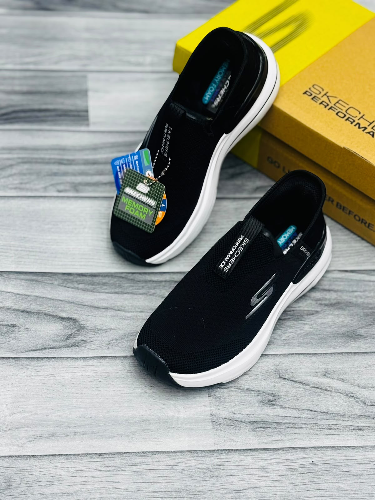 Black and white Skechers Hyper Burst women's slip-on sneakers with Memory Foam tag