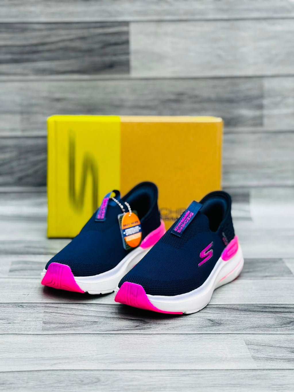 Navy blue and hot pink Skechers Hyper Burst women's slip-on sneakers with Stretch Fit tag