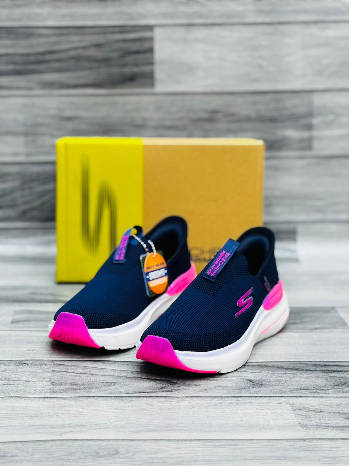Navy blue and hot pink Skechers Hyper Burst women's slip-on sneakers with Stretch Fit tag