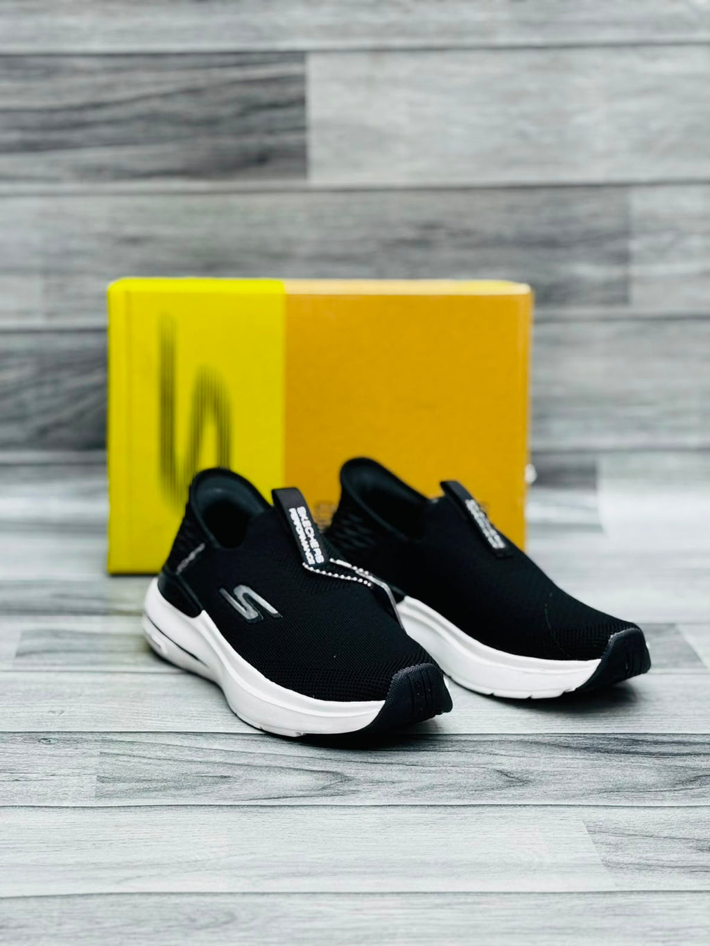 Black and white Skechers Hyper Burst women's slip-on sneakers with Memory Foam tag